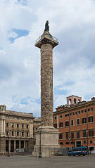 Longue colonne en pierre avec une statue au sommet.