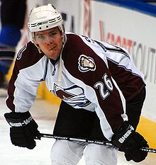 photographie d'un joueur de hockey avec un maillot blanc