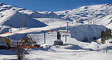 Domaine de ski enneigé avec des remontées mécaniques.