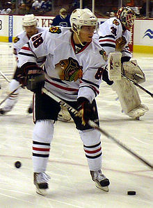 Photographie d'un joueur de hockey avec un maillot blanc