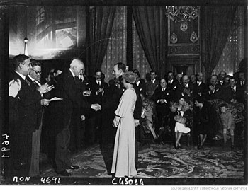 Maurice de Fontenay, président du Conseil de Paris, remet la médaille au couple Joly-Brunet lors d'une réception des athlètes olympiques français à l'hôtel de ville en 1932.