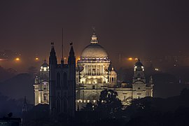 Clocher de la cathédrale anglicane Saint-Paul et en arrière-plan le Victoria Memorial. Lors d'une nuit brumeuse d'hiver.