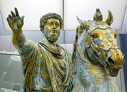 Têtes d'une statue d'un homme et d'un cheval. L'homme est barbu aux cheveux frisés, le cheval a la bouche ouverte.