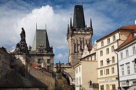 Deux tours de style gothique émergent de bâtiments anciens.