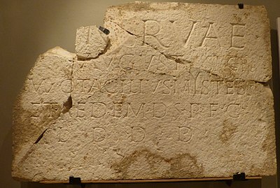 ꟿ pour le prénom romain Manius au début de la troisième ligne d’une pierre du forum romain de Butrint (conservée au British Museum).