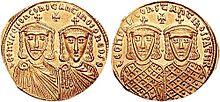 Photographie des deux faces d'une pièce en or, une face représente le portrait de deux hommes et l'autre face le portrait d'un seul homme.