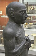 Statue V, détail : haut du corps avec épaule et bras visibles, tête recollée. British Museum.