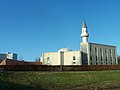 photo d'une mosquée surmontée d'un minaret sur fond de ciel bleu.