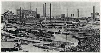 Photo d'une paysage industriel. Quelques hautes cheminées dépassent d'une nuée de bâtiments.
