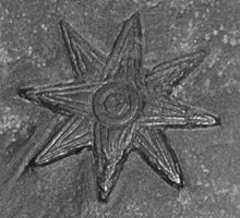 Une étoile est gravée sur une stelle en pierre.
