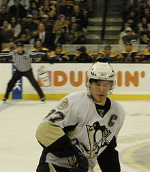 Photographie de Sidney Crosby portant le numéro 87 et le C de capitaine des Penguins.