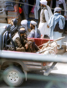 Talibans armés de fusils et de lance-roquettes installés à l'arrière d'un pick-up.