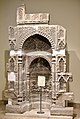 Mihrab en pierre décoré de motifs floraux et des versets 18 et 19 de la sourate al-Imran.