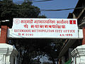 Signboard of Kathmandu Metropolitan City Office in Ranjana script (second row).