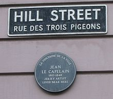 Plaque de rue à Saint-Hélier : en français, et en anglais. Il manque le nom en jersiais : rue ès Trais Pigeons. Et plaque en anglais en l'honneur de l'artiste Jean Le Capelain.