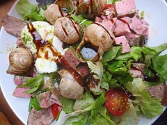 En salade bourguignonne avec jambon persillé et œufs en meurette.