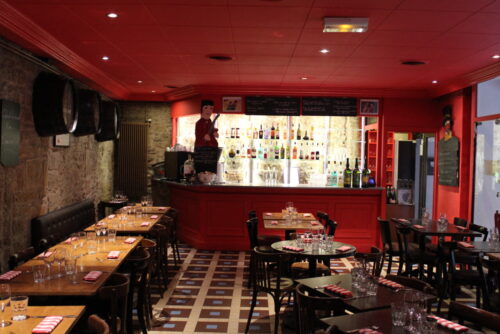 Le bar rouge au fond et le mur en pierre avec les tonneaux incrustés donnent un certain charme au Bouchon des Cordeliers.