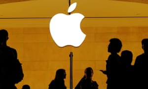 Customers walk past an Apple logo inside an Apple store at Grand Central Station in New York.