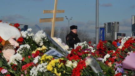 Un officier de police stationne près d'un lieu d'hommage aux victimes de l'attentat près de Moscou, en Russie, le 25 mars 2024. (OLGA MALTSEVA / AFP)