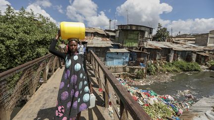 Une femme porte un bidon d'eau potable à Nairobi, le 20 mars 2024. Le choléra prospère quand il y a un problème d’accès à l’eau potable, comme au Kenya, où les autorités s'inquiètent d'une résurgence de la maladie. (DANIEL IRUNGU / EPA / AFP)